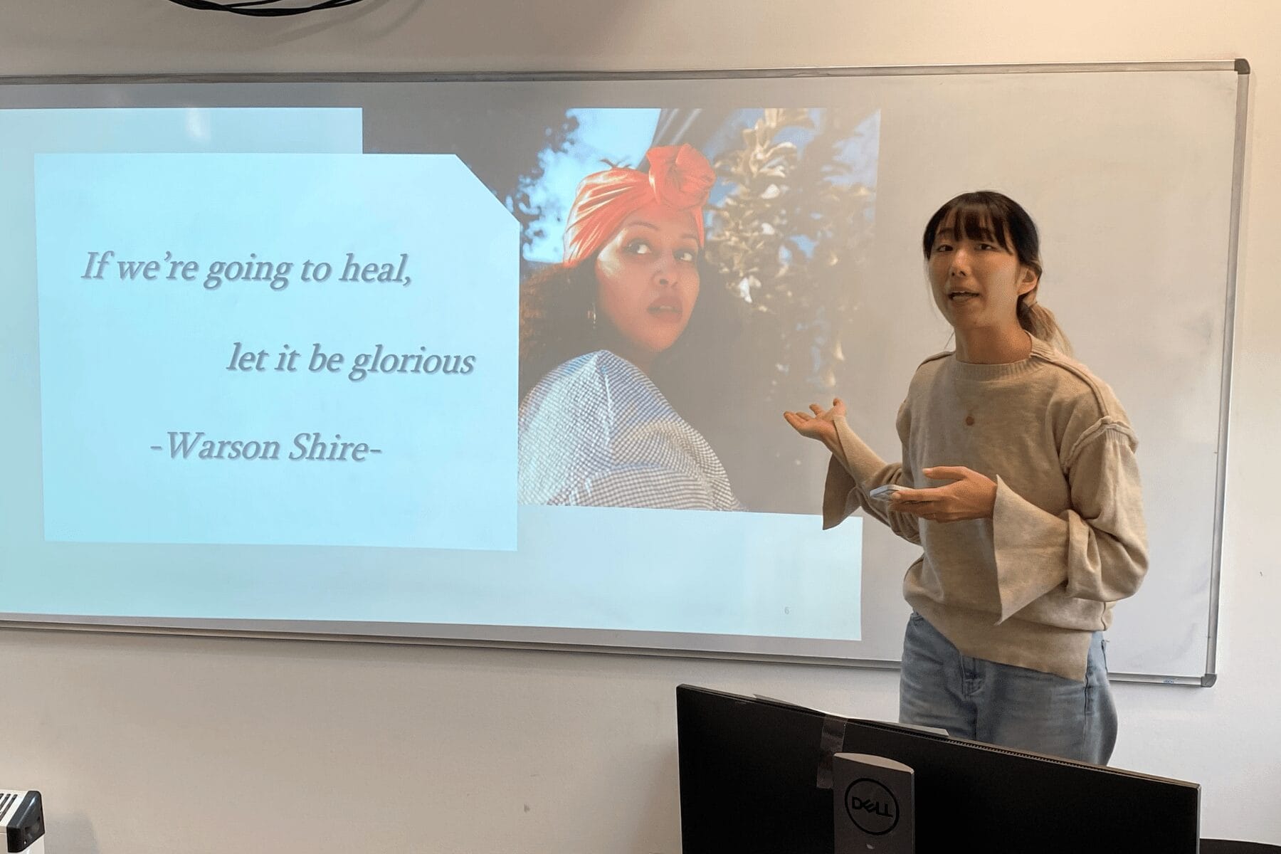 Lecturer referring to projected image with text.