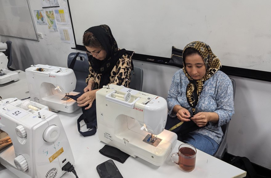 Two women sewing at the English for Sewing class to recognise International Women's Day
