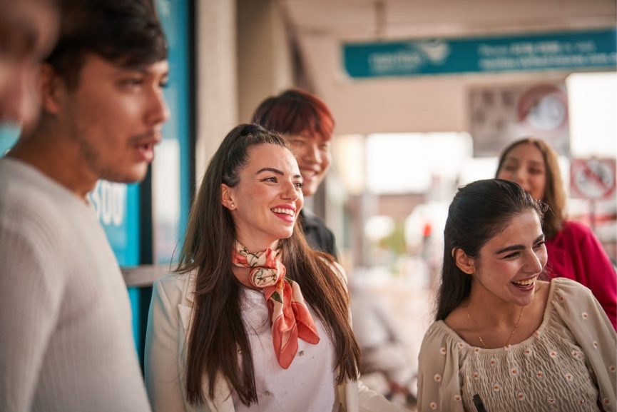 A group of smiling Youth Class students outside the Navitas Skilled Futures college