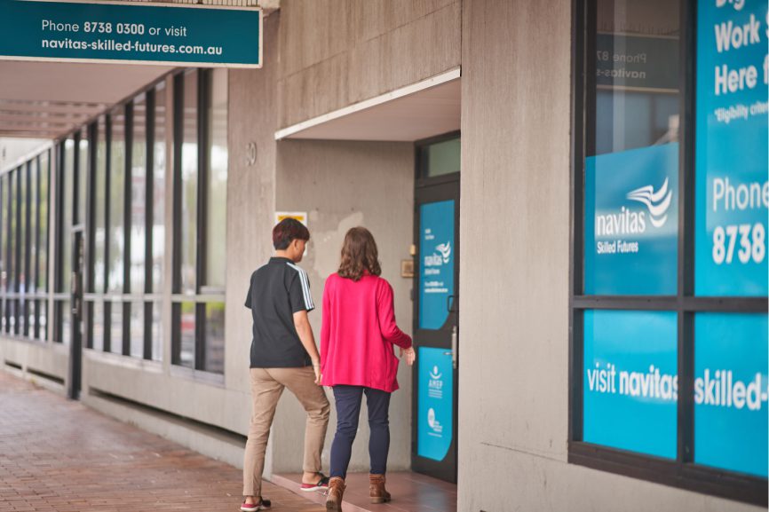 Sanja Nikolic walking through the entrance of the Navitas Skilled Futures college with a friend