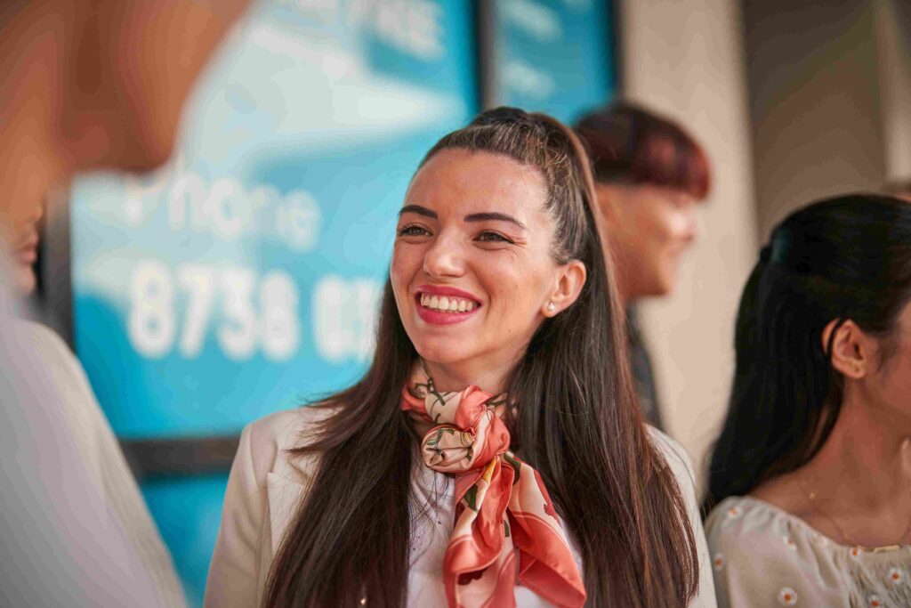 A smiling Navitas Skilled Futures volunteer tutor standing with students outside a college