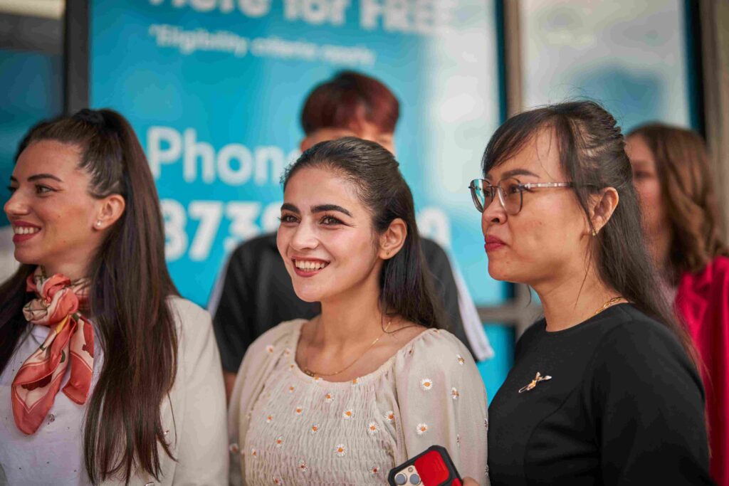 Three students standing outside a Navitas Skilled Futures college for youth class