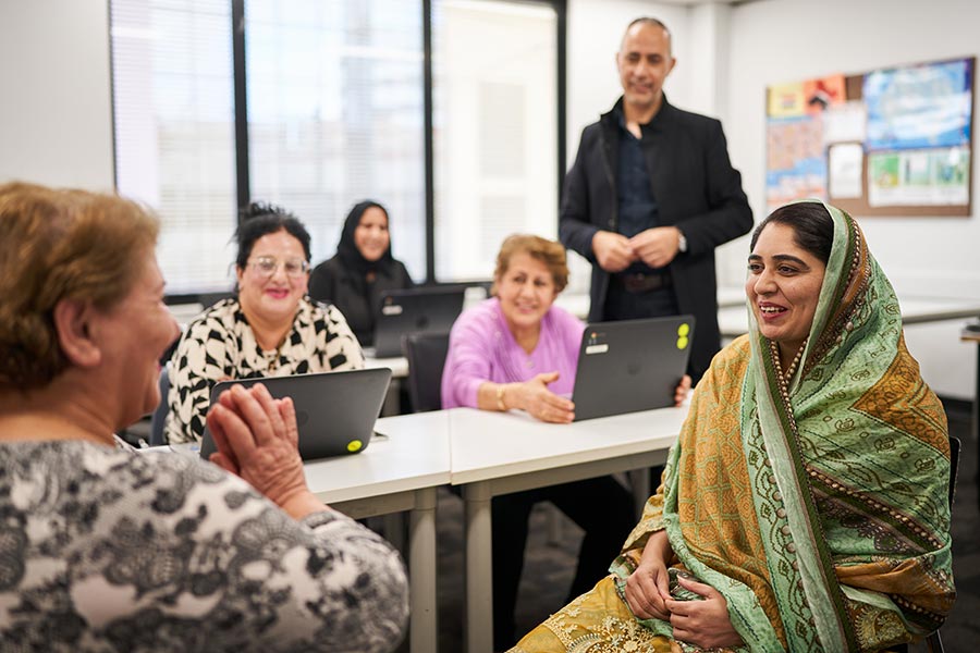 Several NSF students sitting in a classroom and talking to one another during their Conversation Skills short course class (900x600).