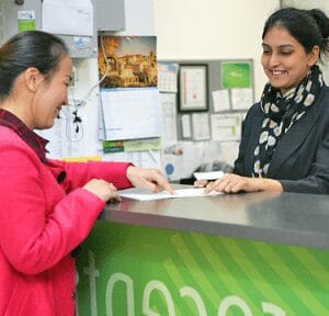 Navitas receptionist helping someone fill in forms