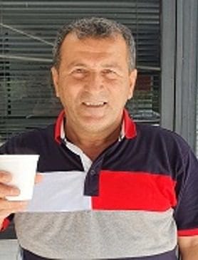 Photo of man, smiling, holding coffee