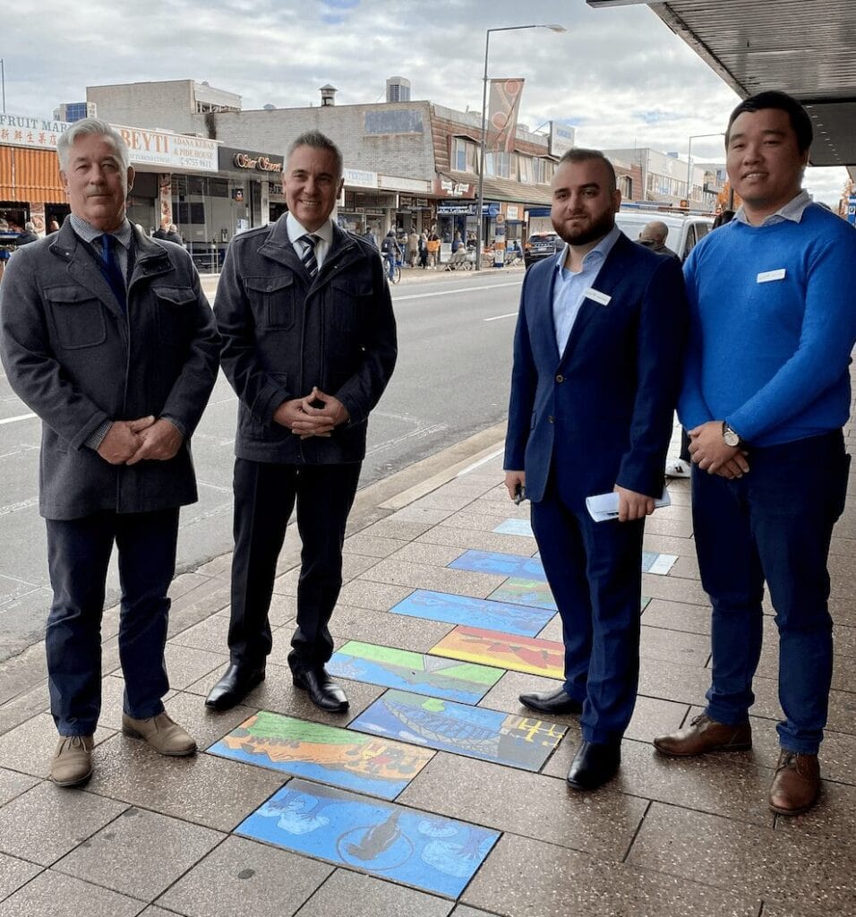 Four men of different ethnicities standing next to sidewalk art