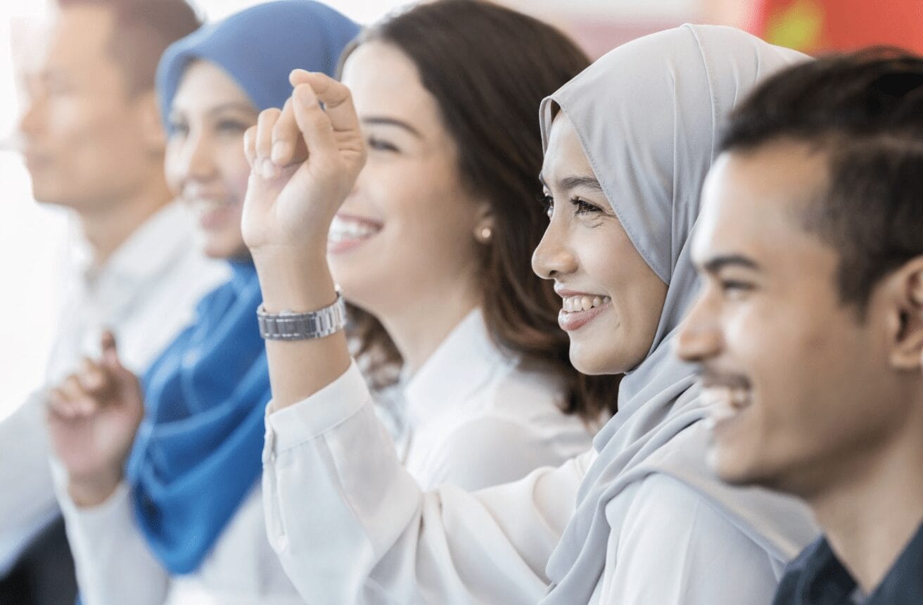 Women in hijab raising her hand in class