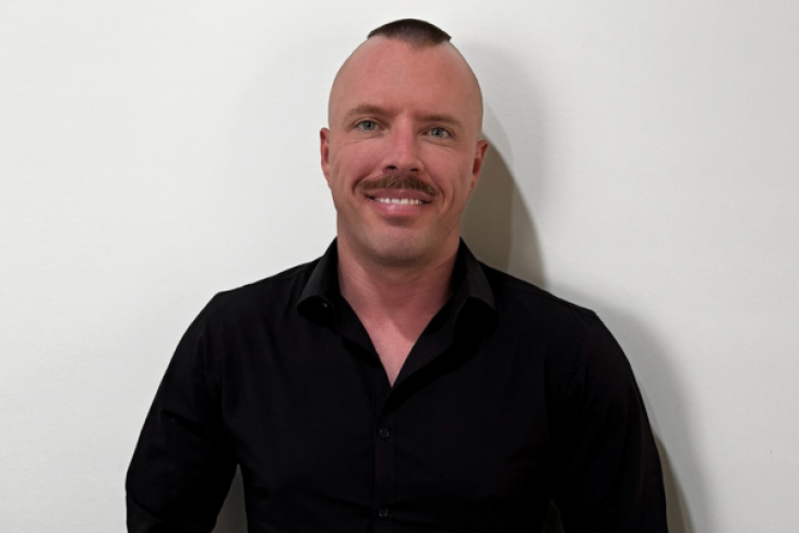 Profile photo of Alex Simpson against a white wall background - creator of the Global Voices Content Mentorship Program at NSF