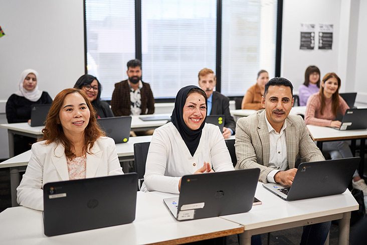 Three PtW students at Navitas Skilled Futures sitting together at a desk in front of laptops (732x488)