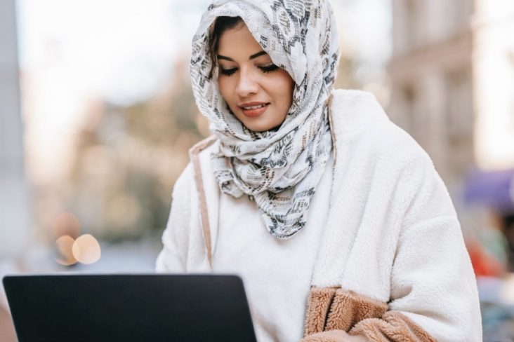 Woman sitting down looking at a laptop
