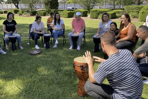 People sitting in a drum circle outside